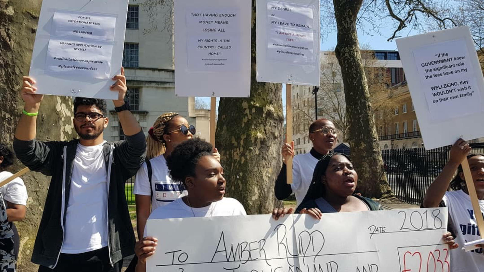 An image of young students with placards saying "Let Us Learn"