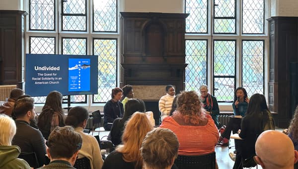 Hahrie Han talking on a microphone sat with a panel of four other people, in front of a seated crowd in Toynbee Hall.