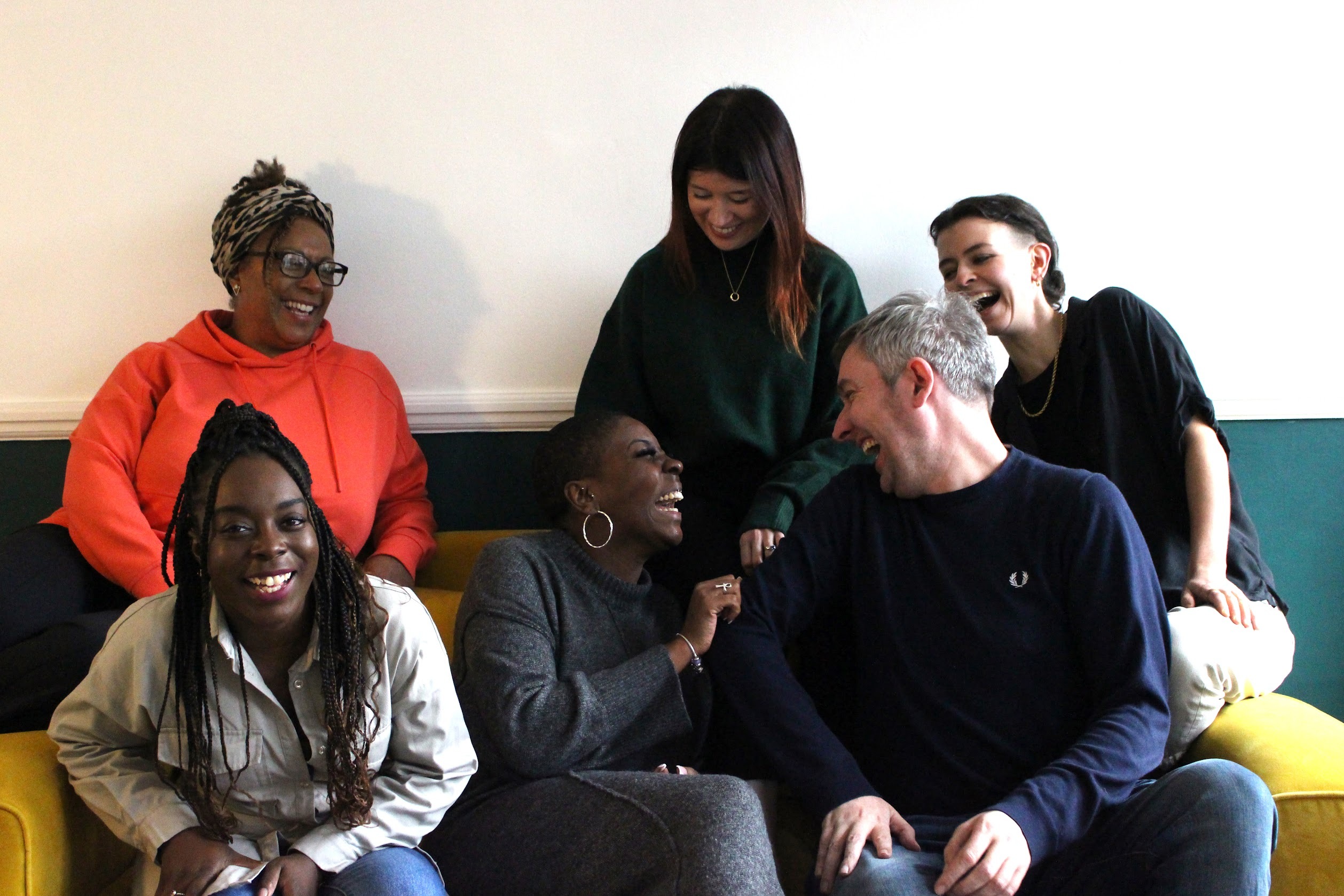 An image of 6 people laughing and smiling.