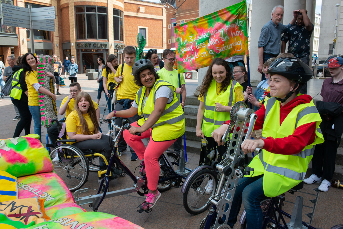 An image of young people with high visibility jackets on bicycles.