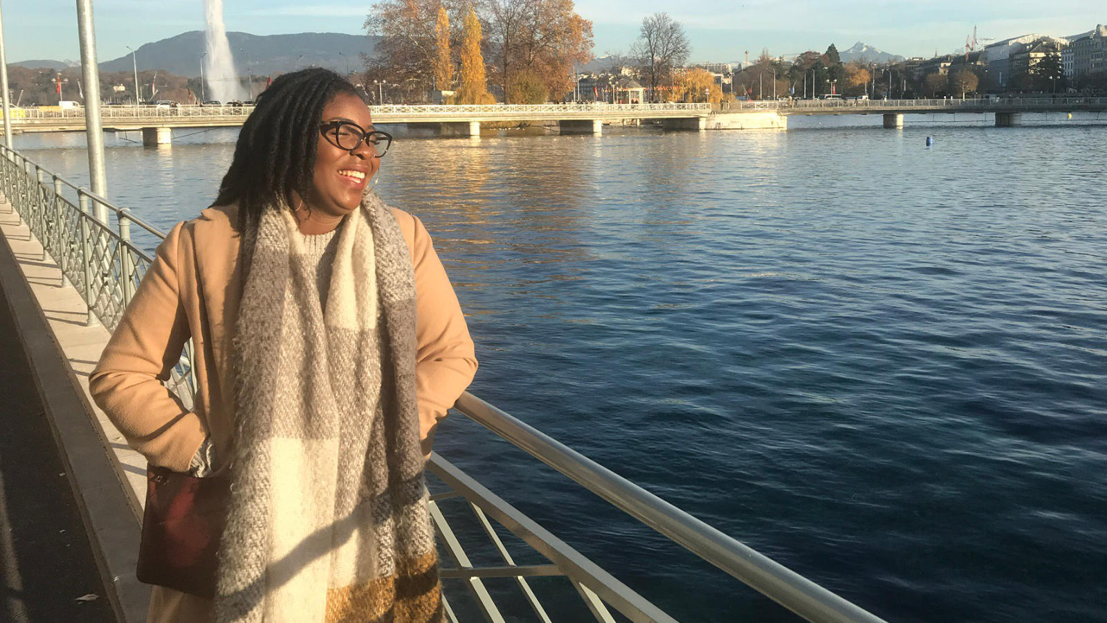 An image of a black woman smiling by a river.