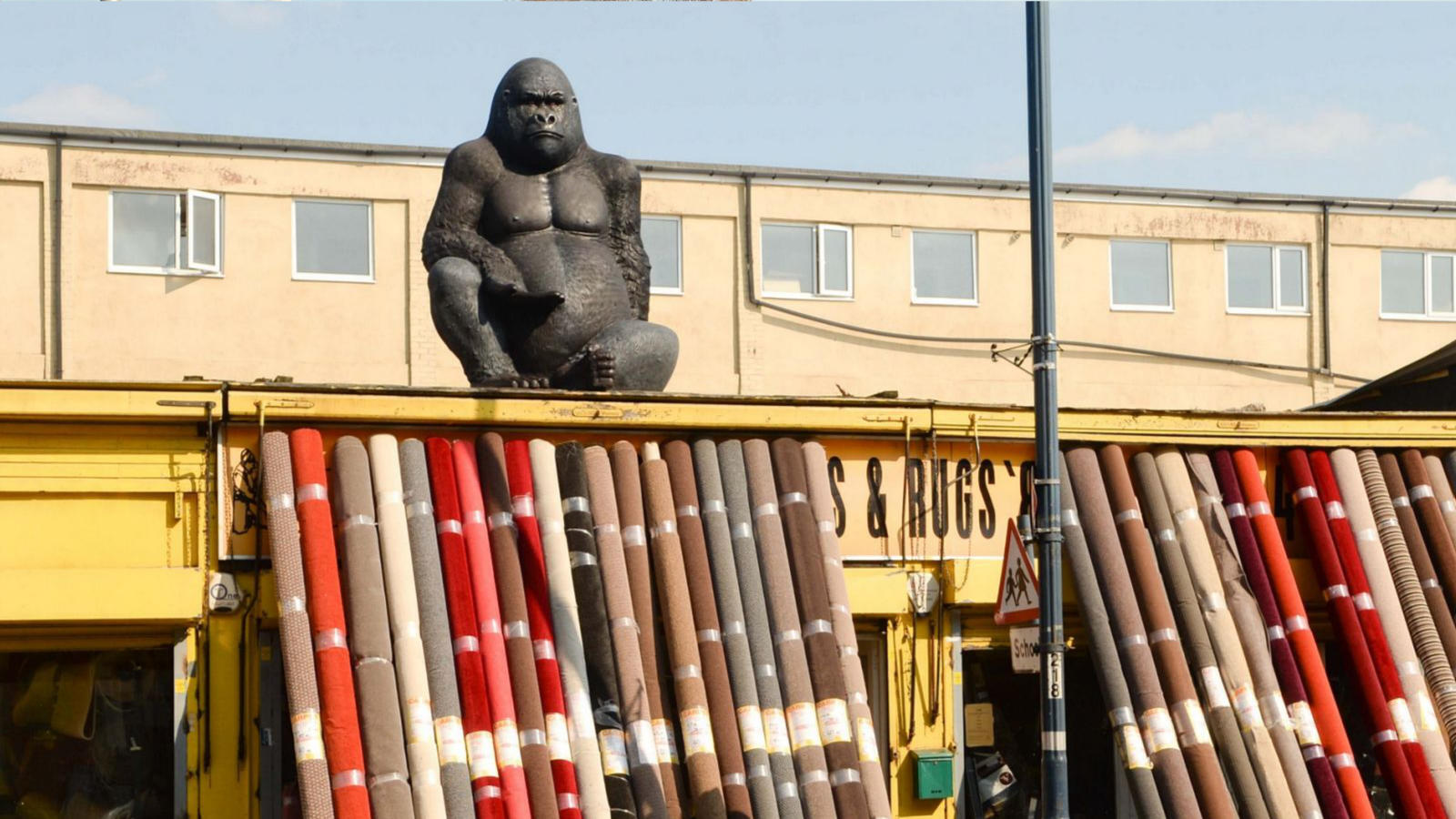 An image of a building with a big gorilla sitting on the top.