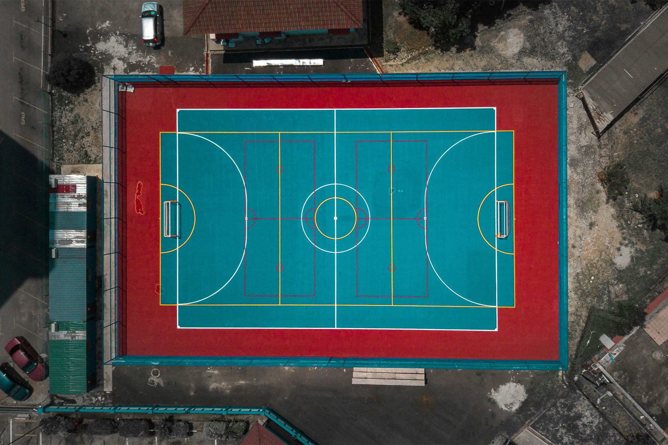 An overhead view of a ball court with overlapping line boundaries for various sports.